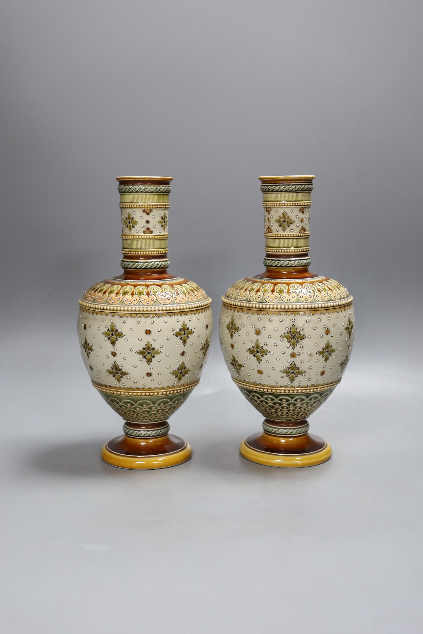 A pair of late 19th century Mettlach vases, 26 cms high.